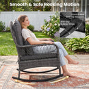 A woman relaxes on the Patio Rattan Rocking Chair with Cushions - 400 LBS Capacity by DirectDeals, featuring a smooth, safe rocking motion, anti-tip stoppers, and anti-slip strips on a stylish outdoor rug.