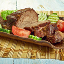 Sliced roast beef served on a decorative plate with lettuce, cucumber slices, and tomato wedges, lightly seasoned with The Spice Lab Hawaiian Red Alaea Sea Salt Fine Grain by The Spice Lab, placed on a bamboo mat.