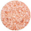 A close-up view of The Spice Lab Himalayan Pink Salt Coarse Grain crystals showcases rough, irregularly shaped grains in light pink and white hues, arranged in a circular frame on a white background—ideal for refilling your salt grinder.