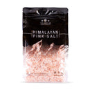 A clear plastic bag of The Spice Lab Himalayan Pink Salt Coarse Grain, filled with coarse pink salt crystals ideal for your salt grinder, stands upright against a white background.