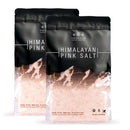 Two resealable bags of The Spice Lab Himalayan Pink Salt Fine Grain, featuring fine pink salt crystals ideal for cooking, all in stylish black-and-pink packaging.