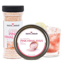 A jar and tin of The Spice Lab Pink Himalayan Salt Cocktail Rimmer are displayed, alongside a cocktail glass rimmed with Pink Himalayan Salt from The Spice Lab, garnished with a lime slice and filled with a pink margarita over ice.