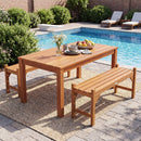 A 40-Inch Outdoor Bench with Contoured Seat - Set of 2 by DirectDeals is on a poolside rug near a hardwood dining table with flowers, dishes, and fruit. Green bushes and lounge chairs complete the scene.