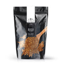 Presented in a black resealable bag, The Spice Lab Scotch Bonnet Sea Salt boasts a bold Caribbean-inspired flavor. The upright packaging features The Spice Lab branding along with an image of a wooden spoon cradling the coarse, brownish-red salt. Perfect as a spicy finishing salt, this stylish bag stands out vividly against a white background.
