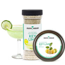 A margarita glass with a lime slice and a salt rim sits next to two containers—one tall, one round—of The Spice Lab Key Lime Salt Cocktail Rimmer, showcasing the perfect option from The Spice Lab for all your Margarita Rimmer or Cocktail Rimmer needs.