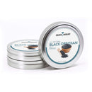 Three metal tins labeled The Spice Lab Black Obsidian Salt Cocktail Rimmer by The Spice Lab, with the front tin open to reveal black salt in a wooden bowl and spoon. Perfect as a striking Margarita Salt or versatile Cocktail Rimmer. Net weight: 3.2 oz (91 g).