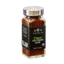 A clear glass jar with a silver lid holds The Spice Lab Organic Chili Powder Blend, a versatile Tex-Mex seasoning from The Spice Lab. The jar displays the rich reddish-brown blend through its transparent sides and features a black label accented with white and green text.