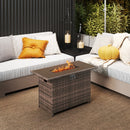 A cozy patio showcases the 44.5 Inch Propane Fire Pit Table Rattan Gas 2-in-1 with Stainless Steel Burner by DirectDeals, nestled between two cushioned outdoor sofas, with hanging candles and plants adding to the inviting atmosphere.