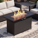 The 44.5″ Propane Fire Pit Table with 50,000 BTU Burner by DirectDeals is the centerpiece among wicker patio furniture and cushions atop a patterned rug on a stone patio.