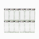 Twelve empty French glass spice jars from The Spice Lab are displayed in two rows of six against a white background, featuring stainless-steel lids for neat and stylish seasoning storage.