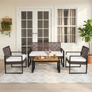 The DirectDeals 4-Piece Patio Conversation Set with Acacia Coffee Table sits on a patterned rug by French doors, lush plants, and a cream wall, perfect for relaxing with drinks and snacks.