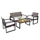 The DirectDeals 4-Piece Patio Conversation Set with Acacia Coffee Table includes two armchairs, a loveseat, and a black metal frame table. White cushions included; table shown with flowers, cups, and a magazine.
