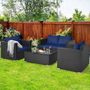 Outdoor patio set with dark wicker furniture and blue cushions surrounds a glass coffee table, while the DirectDeals Outdoor Storage Cabinet Patio Wicker Organizer with Drawer keeps essentials handy. A blanket is draped over one armchair.