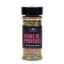 A clear spice jar from The Spice Lab Flavors of Provence Seasoning Set, filled with dried green herbs and topped with a black cap and a distinctive black and pink label, makes an essential addition to any gourmet seasoning collection—perfect for elevating French and Italian-inspired dishes.