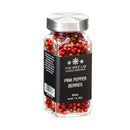 A glass jar of The Spice Lab Pink Pepper Berries (Whole) Brazilian Pink Peppercorns, featuring a silver lid and black label, filled with whole pink pepper berries.