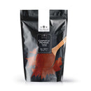 A black resealable bag of The Spice Lab Chipotle Chile Powder, labeled No. 3077, 1 lb, is shown. This premium bulk foodservice spice from The Spice Lab offers a rich, smoky BBQ flavor. The front of the package features a wooden spoon filled with reddish-brown chipotle chile powder.