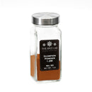 A clear glass jar with a metal lid contains a reddish-brown powder labeled The Spice Lab Scorpion Chile Powder, Net Wt. 1oz. Produced by The Spice Lab, this chile powder is renowned for its extreme heat. The jar is displayed against a white background.
