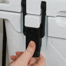 White 25-quart cooler by Bison with a hand opening the black latch.
