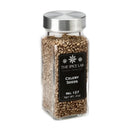 A clear glass jar with a silver lid is filled with The Spice Lab Whole Celery Seeds—a classic choice for savory seasoning and pickling blends. The black label displays The Spice Lab brand, Cooking Inspiration, Whole Celery Seeds, No. 127, Net Wt. 2oz.
