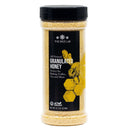 A clear plastic jar of The Spice Lab Granulated Honey displays yellow granules and features a black label adorned with honeycomb and bee graphics. Ideal for BBQ rubs or bulk foodservice applications, this jar contains 8.7 oz (247g).