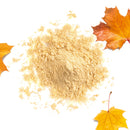 A pile of light brown The Spice Lab Maple Sugar Powder is scattered on a white surface, surrounded by three orange maple leaves, suggesting an autumn theme.
