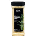 A clear plastic container of The Spice Lab Turbinado Sugar with a black lid features a label adorned with a sugarcane illustration, highlighting that this all-natural, less processed sugar from The Spice Lab is ideal for sweetening tea, coffee, baking, and more.