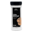 A clear plastic bottle of The Spice Lab Sanding Con AA Sugar with a black lid features a cupcake illustration and showcases the sparkling white sugar crystals inside. The black label, accented with white and tan, highlights this all-natural sanding sugar as perfect for decorative baking—ideal for use as cupcake sprinkles or to add a touch of sparkle to your favorite desserts.