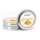 Three round tins labeled The Spice Lab Zesty Orange Sugar Cocktail Rimmer by The Spice Lab. One tin stands upright, displaying an image of an orange slice on the lid, while two tins are stacked horizontally behind it. This vibrant orange cocktail rimming sugar is the perfect citrus garnish or margarita rimmer for your favorite drinks.