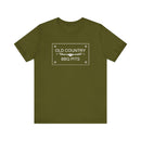 The Old Country BBQ Pits Vintage Logo T-Shirt by Printify features an olive green design with a rectangular white OLD COUNTRY BBQ PITS logo and decorative detail, making it the perfect pitmaster tee for your collection.