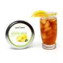 A glass of iced tea garnished with a lemon wedge and a sugared rim—crafted using The Spice Lab Lemon Drop Sugar Cocktail Rimmer by The Spice Lab—sits beside a tin labeled “The Spice Lab Lemon Drop Sugar Cocktail Rimmer,” featuring vibrant images of lemons on the lid. This setup is ideal for adding the perfect finishing touch to your favorite citrus cocktails.