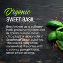 The Spice Lab Organic Sweet Basil by The Spice Lab is showcased with fresh basil leaves resting on a dark wooden surface, accompanied by text detailing its aromatic qualities and versatile culinary uses. The essential role of this organic sweet basil in Italian-inspired cooking is highlighted, while scattered seasonings add visual detail.