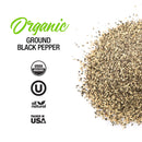 A pile of ground black pepper, finely milled from organic peppercorns, is displayed alongside labels featuring “The Spice Lab Organic Ground Black Pepper” and certification logos for USDA Organic, kosher, all natural, and packed in the USA—perfect for seasoning blends or everyday use.