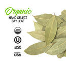 A pile of dried whole bay leaves sits next to text reading The Spice Lab Organic Hand Select Bay Leaf, accompanied by icons for organic, kosher, all natural, and Packed in USA—perfect for adding rich flavor to soups and stews.