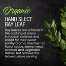 A sprig of whole, fresh The Spice Lab Organic Hand Select Bay Leaf rests beside text highlighting the aroma and versatile use of this organic bay leaf by The Spice Lab in cooking soups, stews, meats, seafood, and vegetables, set against a dark background.
