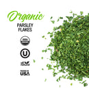 A pile of The Spice Lab Organic Parsley Flakes is displayed on a white background—ideal for garnishing or enhancing the flavor of any dish. Text reads “The Spice Lab Organic Parsley Flakes,” with icons indicating USDA Organic, Kosher, All Natural, and Packed in USA.