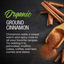 A wooden scoop of ground cinnamon spills onto a dark surface beside several cinnamon sticks. Text highlights The Spice Lab Organic Ground Vietnamese Saigon Cinnamon, emphasizing its bold aroma, sweet warmth, and high-oil content that define this premium spice’s rich flavor profile and versatile culinary uses.