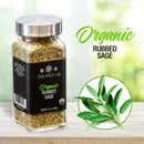 A jar of The Spice Lab Organic Rubbed Sage by The Spice Lab rests on a wooden surface beside fresh sage leaves, with the text “Organic Rubbed Sage.” Ideal as poultry seasoning or sage for stuffing, the softly blurred background adds a warm touch.