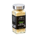 A clear glass jar with a silver lid holds The Spice Lab Organic Hulled Sesame Seeds—ideal for baking or adding a nutty crunch to stir-fries. The black label features the brand name, displays USDA organic certification, and the net weight is 2 oz (56g).