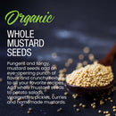 A wooden spoon filled with The Spice Lab Organic Whole Mustard Seeds sits on a dark surface, with some seeds scattered nearby. Text describes the uses and flavor of The Spice Lab’s organic whole mustard seeds, highlighting their popularity in pickling and brining recipes for adding robust, tangy flavor.