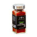 A clear glass jar with a silver lid, labeled The Spice Lab Organic Smoked Paprika, contains vibrant red powder. The black label displays product information along with the USDA organic seal. Renowned for its smoky-sweet flavor, The Spice Lab’s organic smoked paprika is an excellent choice for enhancing BBQ rubs. The jar stands upright against a white background.