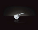 The Napoleon Grills PRO Pizza Cutter Premium Stainless Steel (55217) is centered on a dark background, its white ergonomic handle and sharp blade casting a faint reflection on the glossy surface below.