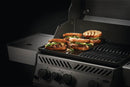 Four sandwiches with meat, cheese, and veggies are grilling on a Napoleon Enameled Cast Iron Reversible Griddle for Rogue® 425 by Napoleon Grills; dark grill marks pop against the bread on this outdoor accessory.