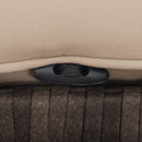 Close-up of a beige cushion with a black plastic clip on a dark woven surface, part of the DirectDeals 5 Pieces Patio Rattan Furniture with 2 Ottomans and Tempered Glass Coffee Table-Red—ideal for outdoor gatherings.