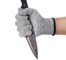 A hand wearing a NULU Safety Glove by NULU Inc., featuring Level 5 cut resistance in gray, holds a large kitchen knife with a black handle against a white background.