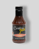 A bottle of Gourmet Carolina Gold Hot Vinegar Pepper Carolina Gold BBQ Sauce with a black label.