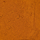 Close-up of The Spice Lab Golden Milk Turmeric Tea Superfood Premium Powder—a fine orange-brown powder with a slightly uneven texture and small clumps visible.