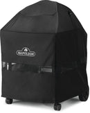 The Napoleon 22 Inch Charcoal Grill Cover (61916) by Napoleon Grills is a black, water-resistant cover with a white logo, mesh ventilation strip, and fitted design that leaves the grill’s wheels visible for easy movement.