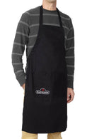 A person wears a Napoleon Grills Black Grilling Apron (62131) over a gray striped long-sleeve shirt and khaki pants, standing against a white background.