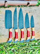 The Texan Knives Best Japanese Kitchen Knife Set features a 13" forged stainless steel chef knife with an olivewood and resin handle, shown with its leather sheath on a wooden surface surrounded by grass.