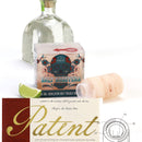 An 8-pack of The Spice Lab Himalayan Salt Tequila Shooters is displayed with its packaging, accompanied by a lime wedge and a bottle of tequila. In the foreground, a section of a patent certificate and technical patent drawing highlight this unique pink Himalayan salt shot glass set from The Spice Lab—an essential addition to any tequila party collection.